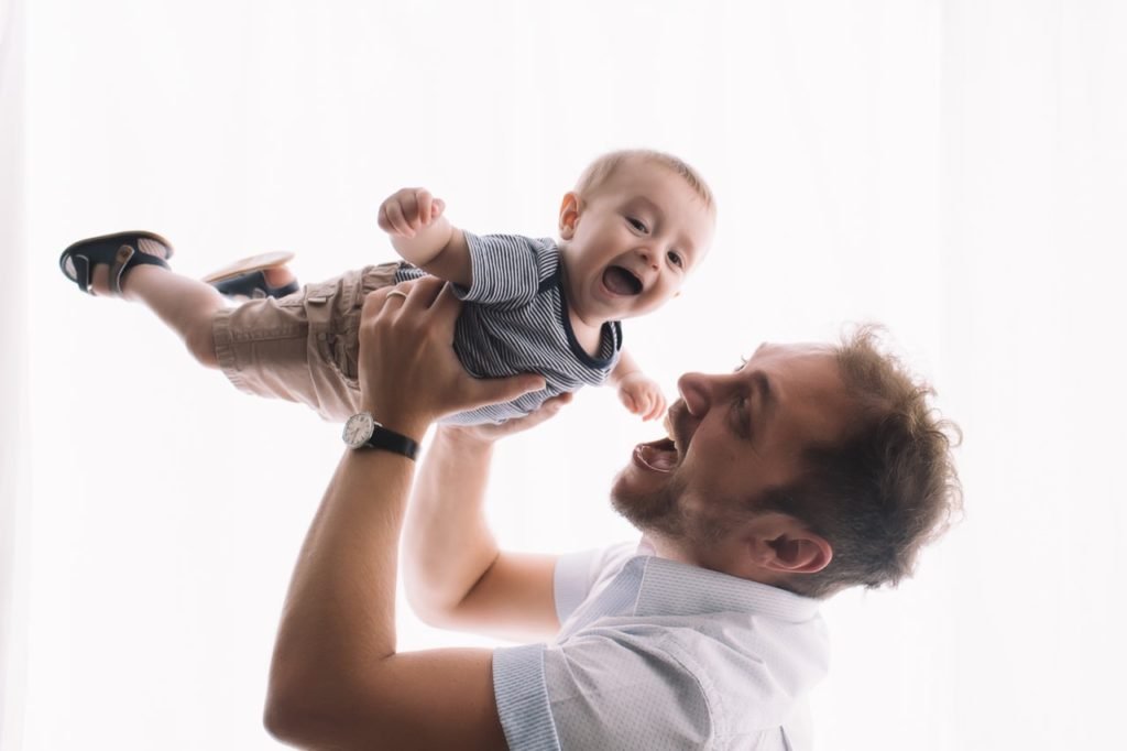 pai e filho fazendo aviãozinho