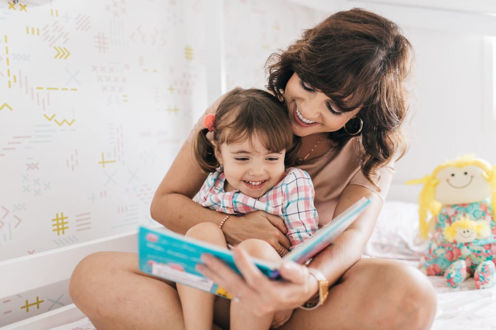 mae lendo livro para filha